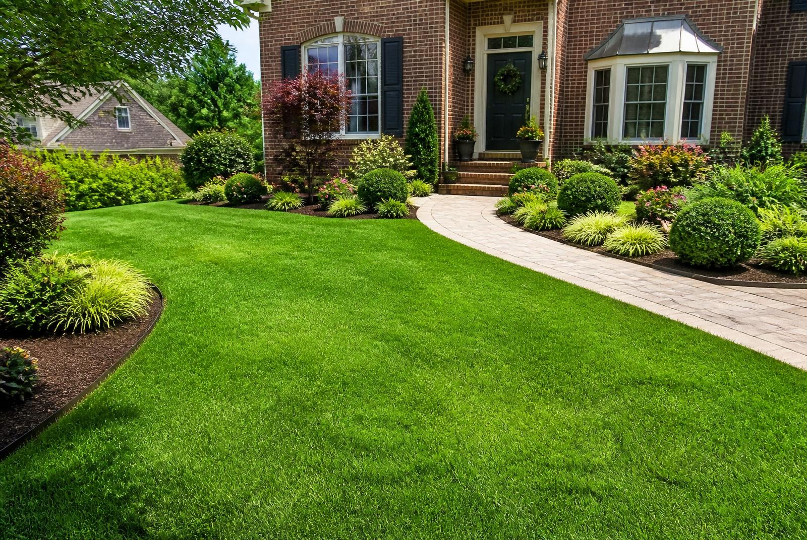 Lush green lawn, manicured beds, and paver walkway at the Halverson residence after Xterra renovation