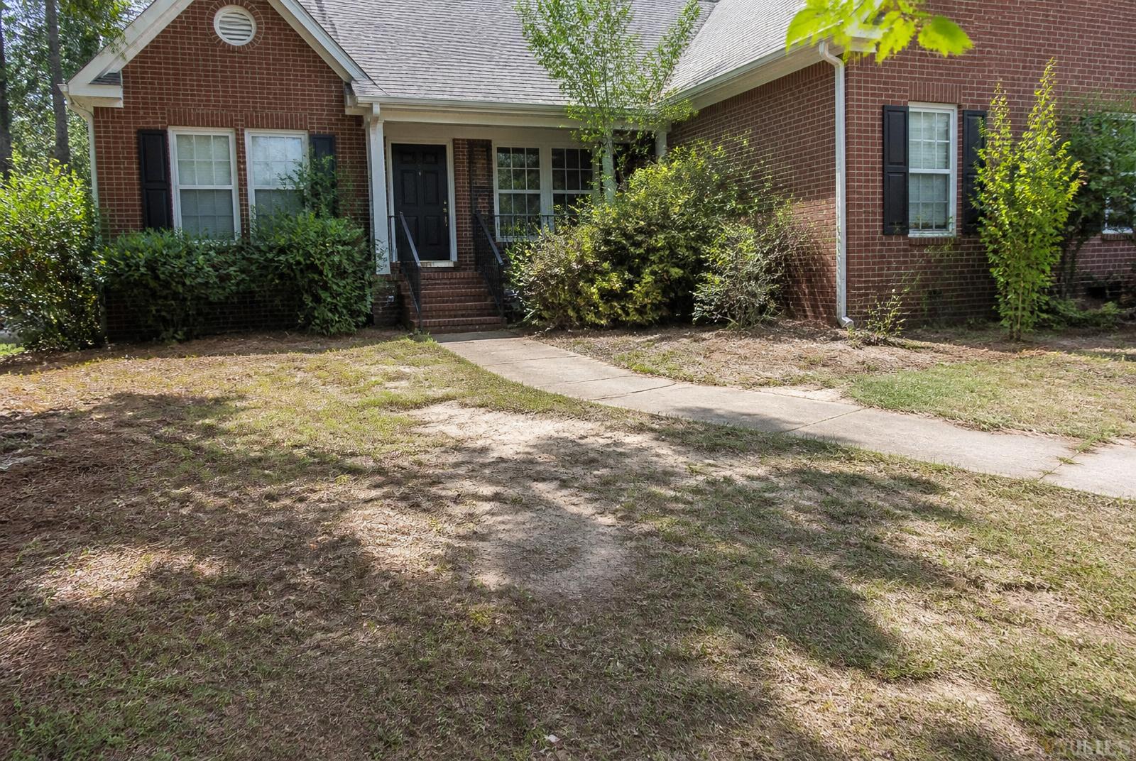 Patchy lawn and overgrown beds at the Halverson residence before Xterra renovation